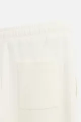 Pantalón negro de corte recto confeccionado en tejido interlock de algodón con elasticidad. Tiene cintura elástica ajustable con cordón, bolsillos frontales y bolsillos traseros de vivo.