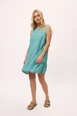 Vestido blanco de lino y algodón, corte suelto, con volados en el ruedo y escote bote.