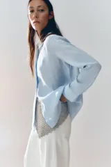 Camisa color ladrillo confeccionada en lino 100%, de corte recto, con cuello solapa, manga larga con puños y cierre frontal con botones.