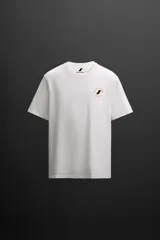Camiseta blanca de algodón con corte relaxed fit, cuello redondo y manga corta. Estampado en el frente con un logo pequeño y en la espalda con un diseño de tablas de surf y texto.