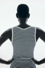 Vestido largo sin mangas, de corte ajustado, con escote redondo ribeteado en blanco y estampado de rayas horizontales blancas y negras.