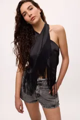 Top amarillo de satén con cuello halter y flecos negros.