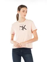 Remera cropped color rosa claro de algodón y elastano, con logo "CK" enmarcado en negro en el frente.