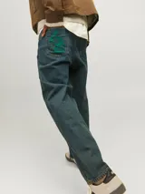 Jean azul de tiro alto y corte baggy. Cierre con botón y tejido de sarga.