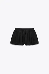 Falda pantalón corta negra de tiro medio, con cintura elastizada y detalle de tejido con volumen y pliegues. Cierre lateral con cremallera oculta.