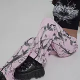 Pantalón rosa con estampado de ramas en negro, tiro alto y corte recto.