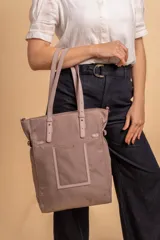 Cartera tipo tote bag color negro, con doble asa de mano y correa bandolera ajustable. Presenta un bolsillo rectangular en el frente.