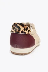 Zapatillas deportivas color beige con detalles en marrón y estampado animal print en el talón. Cierre con cordones y suela de 1,5 cm de altura.