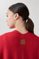 Ruana tejida color rojo con volados.