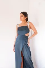 Vestido largo amarillo pálido con escote recto, breteles finos con lazos blancos y falda cruzada con abertura lateral.