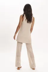 Pantalón palazzo de punto calado negro, con cintura elástica y corte acampanado.