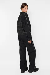 Campera negra oversize con combinación de textil deportivo y sastrero, cierre metálico YKK desmontable, elástico en puños y cintura, vivo a contratono en mangas y cuerpo, forrada al tono.