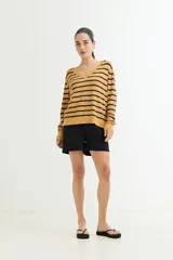 Sweater de algodón color ocre con rayas horizontales negras, escote en V y mangas largas.