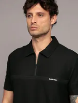 Chomba negra de manga corta con cuello polo y cremallera corta en el frente. Logo de Calvin Klein bordado en el pecho.