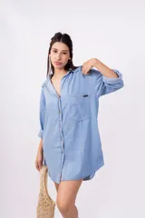 Camisa celeste de mangas largas con puños abotonados, cuello clásico y cierre frontal con botones.