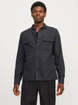 Camisa de algodón orgánico de manga larga color negro, con cuello clásico, dos bolsillos frontales con solapa y cierre con botones.