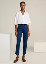 Camisa blanca de lino con cuello alto, escote en V, mangas 3/4 con volumen abullonado y puños elásticos.