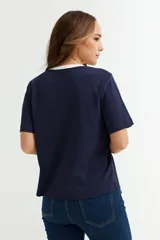 Remera blanca de algodón con cuello redondo y mangas cortas. El cuello es de color azul marino en contraste.