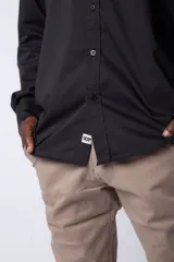 Camisa negra de manga larga con cuello mao y corte clásico.