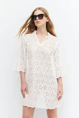 Túnica blanca de broderie, con mangas anchas y corte suelto.