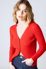Cardigan de punto fino color beige, con escote en V y cierre frontal con botones.