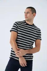 Remera de algodón a rayas horizontales en tonos blanco, marrón y rojo. Tiene cuello redondo, mangas cortas, corte regular y logo estampado en el pecho.