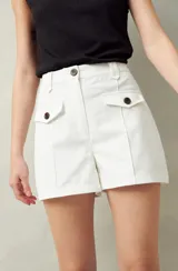 Short blanco de tiro alto con bolsillos delanteros con solapa y botones a la vista.