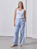 Pantalón celeste a rayas verticales, de lino, corte wide leg y tiro alto con botones decorativos.