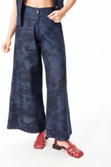 Pantalón de jean liviano con estampado camuflado, corte sastrero y cintura ancha con elástico en la parte trasera.