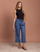 Pantalón capri de jean azul oscuro, con cintura elastizada con cordón ajustable y bolsillos laterales.