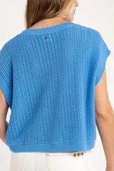 Chaleco de punto color beige con lurex, de corte recto y mangas cortas. Tejido calado con pequeños agujeros.