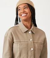 Campera color beige de sarga pana con cuello camisero, abotonada al frente y con dos bolsillos grandes delanteros.