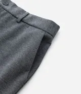 Pantalón de vestir gris con textura, corte slim, con trabillas en la cintura y cierre por botón y cremallera.