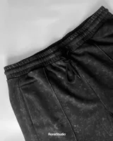 Conjunto deportivo negro con efecto lavado a la piedra, compuesto por una remera de manga corta con logo estampado en el pecho y un short con cordón ajustable en la cintura.