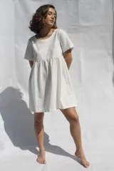 Vestido corto blanco de tusor, con corte evasé, mangas cortas y escote redondo.