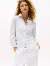 Camisa Tommy Hilfiger de corte regular con rayas verticales celestes y blancas. Tiene cuello inglés, puños y bajo camisero.