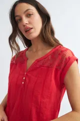 Blusa roja de algodón con detalles de bordado en el canesú y botones al frente.