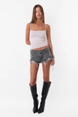 Short de jean gris oscuro, tiro medio, con roturas y ruedo deshilachado.