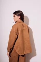 Sobrecamisa negra de gamuza vegana con calce oversize, cuello camisero, cierre con botones a presión, mangas largas con puños abotonados y bolsillos de parche en el pecho.