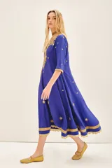 Vestido largo azul con escote en V, confeccionado en viscosa y bordado con piedras e hilos de lurex dorados.