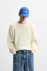 Jersey de hombre color lila, tejido en hilatura de algodón con textura. Tiene cuello redondo, manga larga y acabados en rib con detalle de vuelta.