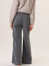 Pantalón de jean color marrón claro, tiro medio/alto, con pierna recta y holgada. Presenta costuras a contratono y cierre frontal con botón.