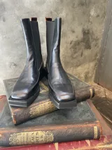 Bota de caña media color negro, con elásticos laterales y confeccionada 100% en cuero.