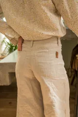 Pantalón de lino color beige, de tiro medio y corte wide leg.