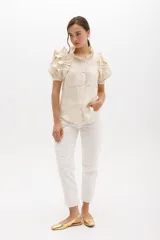 Jean gris lavado, estilo mom fit, con aplique fruncido en forma de espiral en la pierna izquierda, tiro alto, bolsillos delanteros y traseros funcionales, y cierre frontal con botón y cremallera.