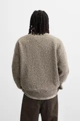 Sweater color arena con textura bouclé, cuello redondo, manga larga y terminaciones en rib.