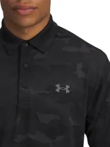 Chomba de golf Under Armour Playoff Polo 3.0 negra con estampado camuflado en tonos oscuros y logo de la marca en el pecho.