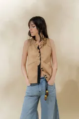Chaleco color beige confeccionado en lino, con cuello mao, volados en la parte delantera y cierre con botones forrados.