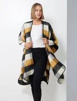 Ruana de tejido soft, color rosa pálido, celeste, gris y beige, con diseño a cuadros. Presenta terminación en zig zag con lana en los bordes y sisa amplia.