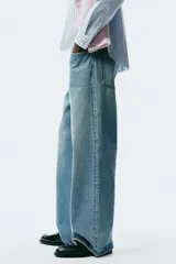 Jeans de cinco bolsillos en denim de algodón rígido, color celeste claro con efecto desgastado. Modelo de corte holgado de cadera a bajo con pierna amplia y tiro caído.